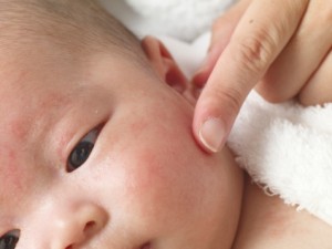 Close-up of an adult touching baby's face